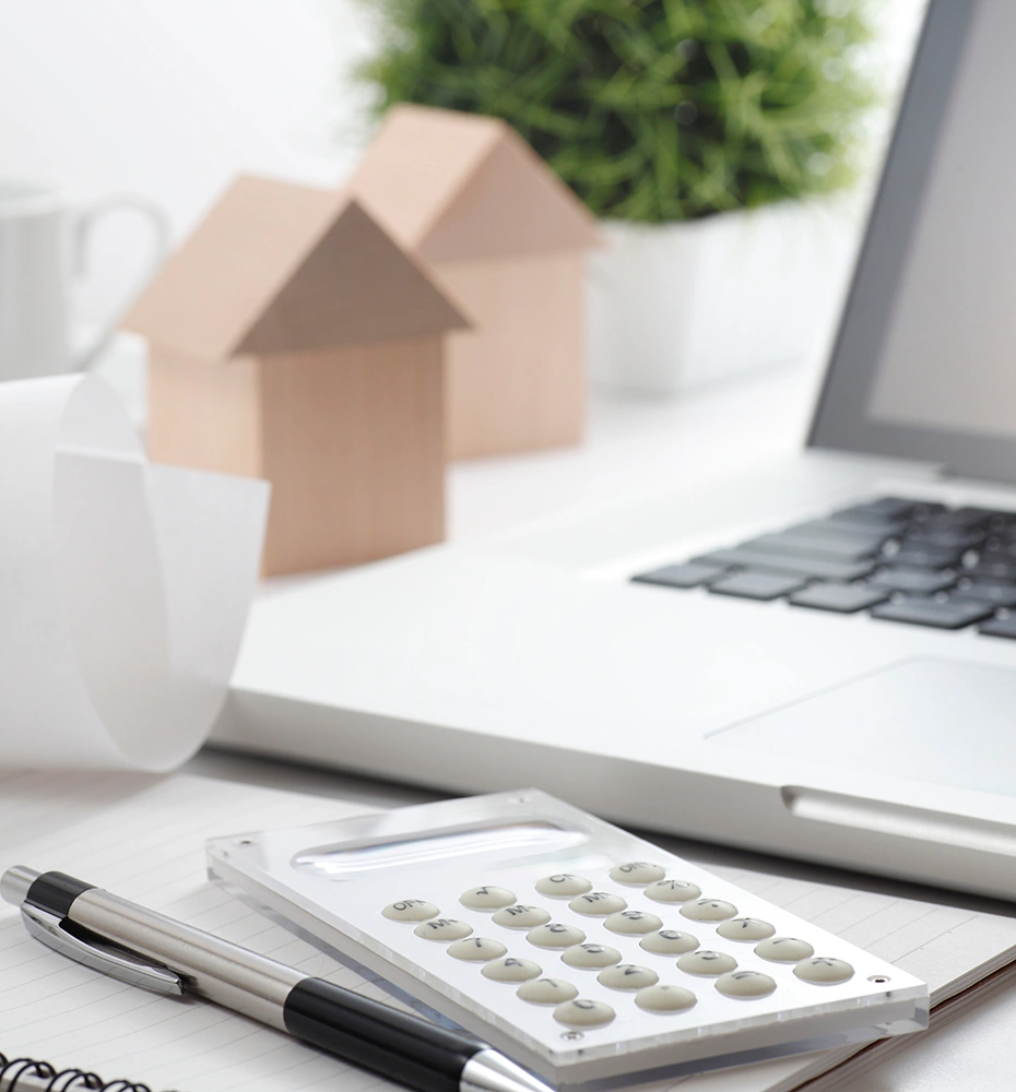 不動産事業、計算機と家の積み木が並んだ写真